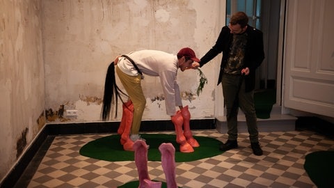 Im Kulturbunker unter dem Diakonissenplatz machen zwei Männer abstrakte Kunst, in dem einer der beiden ein Pferd nachmacht. (Foto: Nele Karlotta Berger) Im Kulturbunker unter dem Diakonissenplatz machen zwei Männer abstrakte Kunst, in dem einer der beiden ein Pferd nachmacht.
