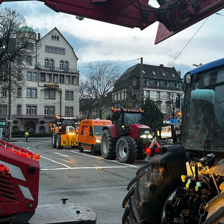 Auf einer Straßenkreuzung blockieren Traktoren von mehreren Seiten die Straße.