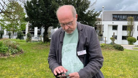 Thomas Ebinger testet auf seinem Handy die neue Baumweg-App in Nagold.