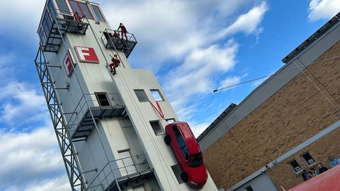 Feuerwehrleute der Feuerwehr Reutlingen seilen sich an einem Trainingsturm ab, um Menschen aus einem abgestürzten Auto zu retten.