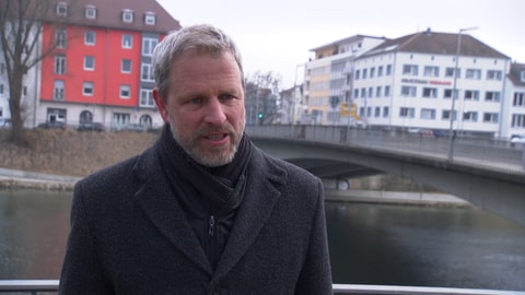 Ulms Baubürgermeister Tim von Winning erklärt vor der maroden Gänstorbrücke, was auf die Autofahrer in Ulm zukommt.
