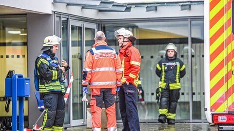 Einsatzkräfte des Rettungsdienstes und der Feuerwehr stehen vor einer Turnhalle in Abtsgmünd. Mehrere Schüler hätten über Beschwerden geklagt und seien vor Ort untersucht worden, teilte die Polizei am Mittwoch mit. (Foto: dpa Bildfunk, picture alliance/dpa | Jason Tschepljakow)