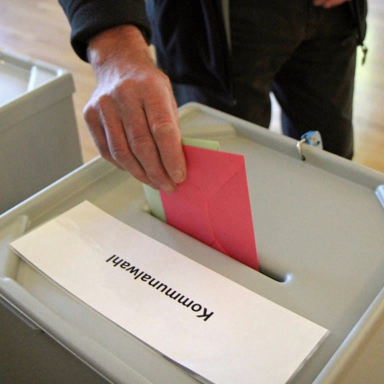 Eine Hand steckt Wahlumschläge in eine Wahlurne: Im kommenden Jahr stehen in Baden-Württemberg die Kommunalwahlen an.