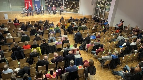 Eine sitzende Reihe von Frauen und Männern auf einer Bühne in einem Saal. Rund 250 Besucherinnen und Besucher verfolgten die Podiumsdiskussion des SWR und der Landeszentrale für politische Bildung zur OB-Wahl in Ulm. (Foto: SWR, Monika Götz) Eine sitzende Reihe von Frauen und Männern auf einer Bühne in einem Saal. Rund 250 Besucherinnen und Besucher verfolgten die Podiumsdiskussion des SWR und der Landeszentrale für politische Bildung zur OB-Wahl in Ulm.