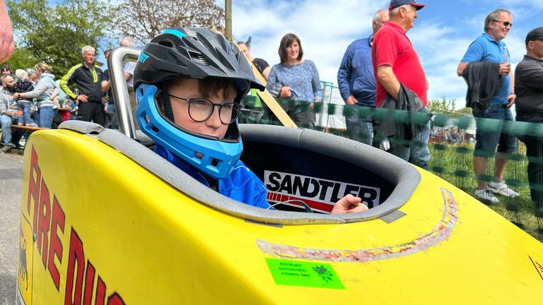 Der 10-jährige Julius Nagel sitzt in seiner Seifenkiste am Start eines Seifenkistenrennens. (Foto: SWR)