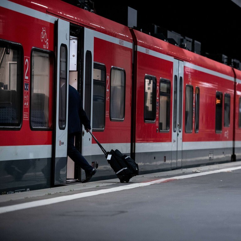 Ein Mann mit Rollkoffer steigt in einen Zug der Deutschen Bahn ein. Die Lokführergewerkschaft GDL hat ihre Mitglieder zum Streik bei der Deutschen Bahn aufgerufen. (Foto: picture-alliance / Reportdienste, picture alliance/dpa | Fabian Strauch)