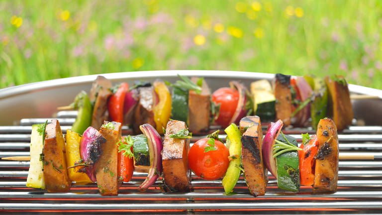 Umweltfreundlich grillen: Vegetarische Spieße mit Seitan und Gemüse auf einem Grill. 
