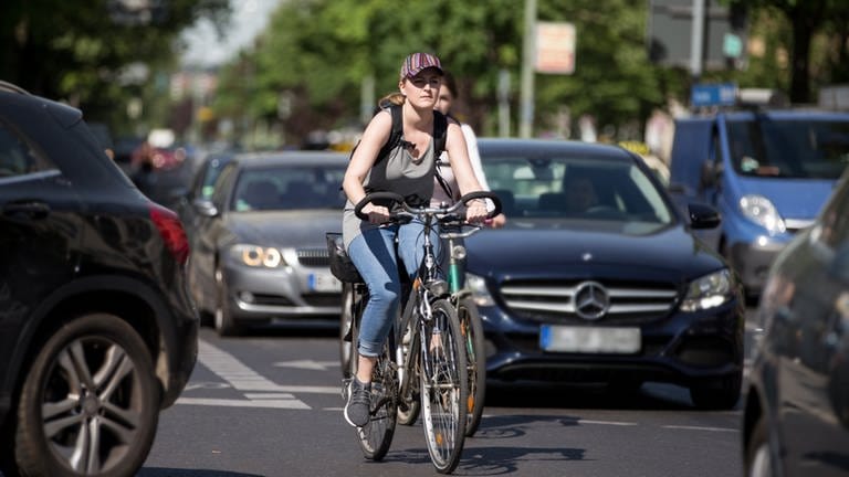 Zwei Fahrradfahrerinnen bahnen sich ihren Weg zwischen den Autos. (Foto: ADFC/april agentur)