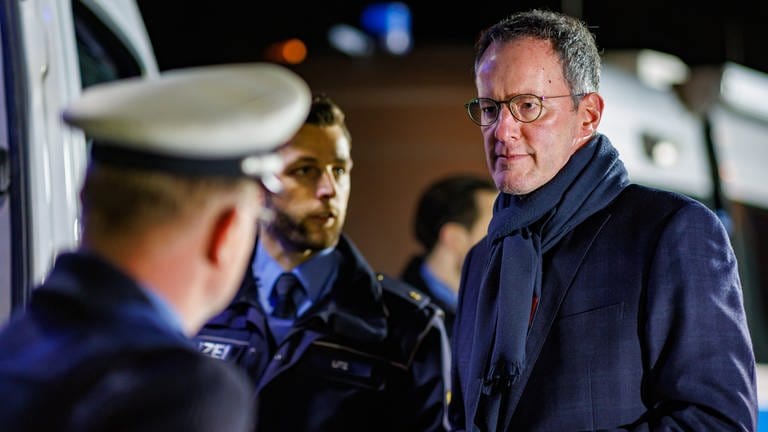 Michael Ebling (r,SPD), Innenminister von Rheinland-Pfalz, bei der Großkontrolle zur Bekämpfung von Geldautomaten-Sprengungen an der A61 im Gespräch mit Polizisten. 
