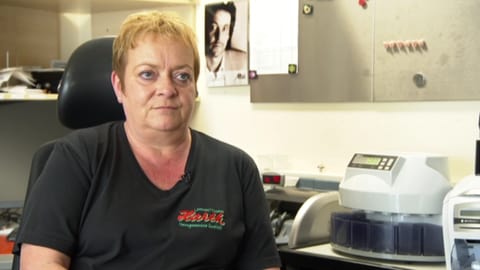Eine Frau im mittleren Alter mit kurzen, blonden Haaren sitzt in einem Schreibtischstuhl und schaut grimmig drein. (Foto: SWR) Eine Frau im mittleren Alter mit kurzen, blonden Haaren sitzt in einem Schreibtischstuhl und schaut grimmig drein.