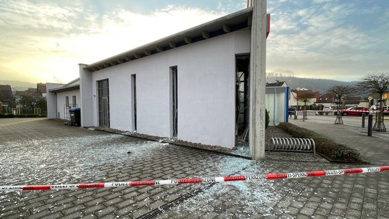 Glasscherben und Absperrband der Polizei - In Fischbach bei Dahn gab es eine Explosion, offenbar wurde ein Geldautomat gesprengt