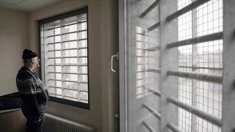 Der als Doppelmörder verurteilte Klaus Bräunig steht vor vergitterten Fenstern im Gefängnis (Foto: SWR)