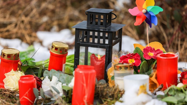 Kerzen und Blumen liegen in einem Wald im südlichen Nordrhein-Westfalen, wo das getötete zwölfjährige Mädchen Luise aufgefunden wurde