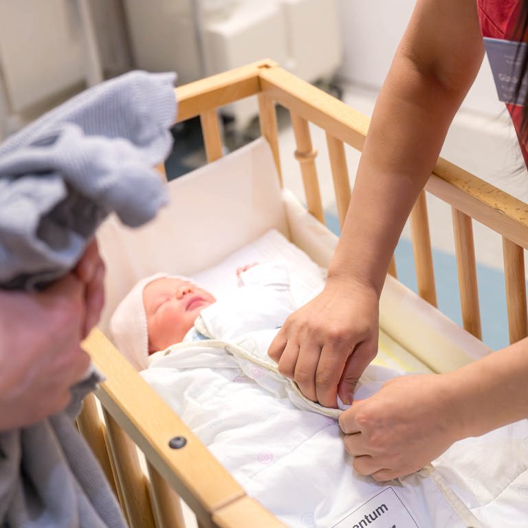 Ein Säugling liegt in einem Bett im Krankenhaus - die Geburtshilfestation Hachenburg wird einen Monat früher als geplant geschlossen. 