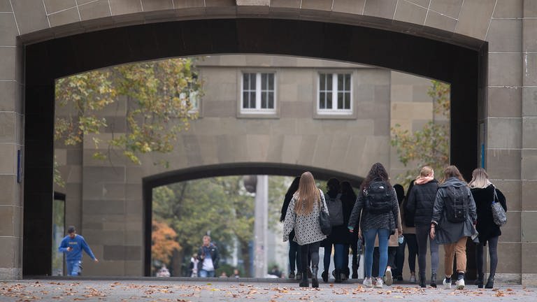 Studierende gehen über den Campus der Johannes Gutenberg-Universität Mainz