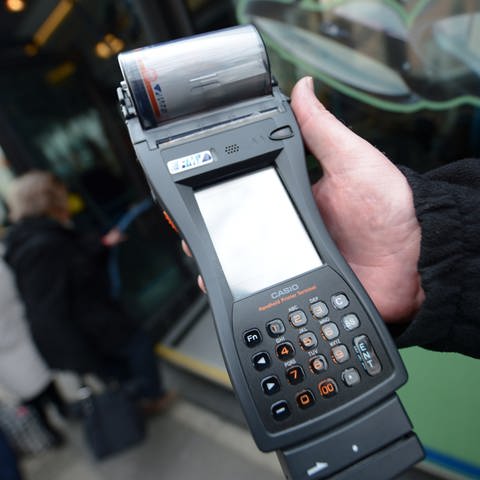 Ein Kontrolleur in Mainz hält ein Fahrscheingerät in der Hand und kontrolliert mögliche Schwarzfahrer.