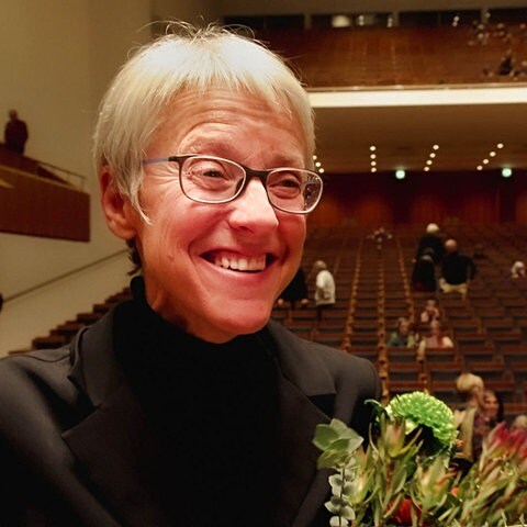 Margaret MacDuffie lacht mit einem Blumenstrauß in der Hand (Foto: SWR)