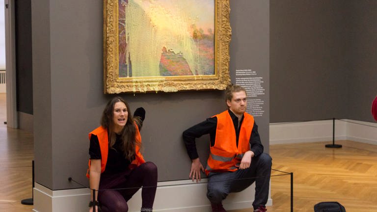 Klimaaktivisten der Klimaschutz-Protestgruppe «Letzte Generation», nachdem sie das Gemälde «Getreideschober» (1890) von Claude Monet im Potsdamer Museum Barberini mit Kartoffelbrei beworfen haben. 