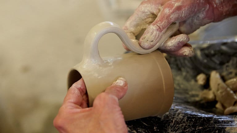 An einem Bierkrug aus Ton wird am 15.09.2015 in der Produktionshalle der Bierkrugfabrik Klaus Ströder GmbH & Co KG in Mogendorf (Rheinland-Pfalz) ein Henkel angebracht. (Foto: picture-alliance / Reportdienste, picture alliance / dpa | Thomas Frey) An einem Bierkrug aus Ton wird am 15.09.2015 in der Produktionshalle der Bierkrugfabrik Klaus Ströder GmbH & Co KG in Mogendorf (Rheinland-Pfalz) ein Henkel angebracht.