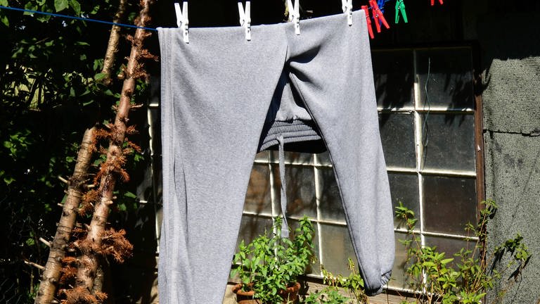Eine Jogginghose hängt auf einer Wäscheleine
