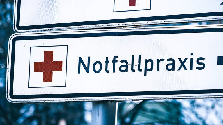 Hinweisschild mit einem roten Kreuz und dem Schriftzug Notfallpraxis