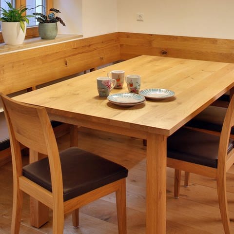 Esstisch mit Eckbank und Stühlen aus Massivholz, Schreinerarbeit. Symbolfoto