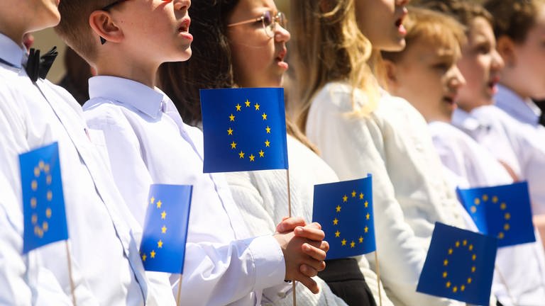 Children hold EU flags while singing the European anthem Ode to Joy during celebration of 18-year of Polish membership in the European Union.