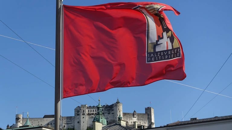 Eine Fahne mit der Aufschrift Salzburger Festspiele 2023, im Hintergrund sieht man die Stadt Salzburg