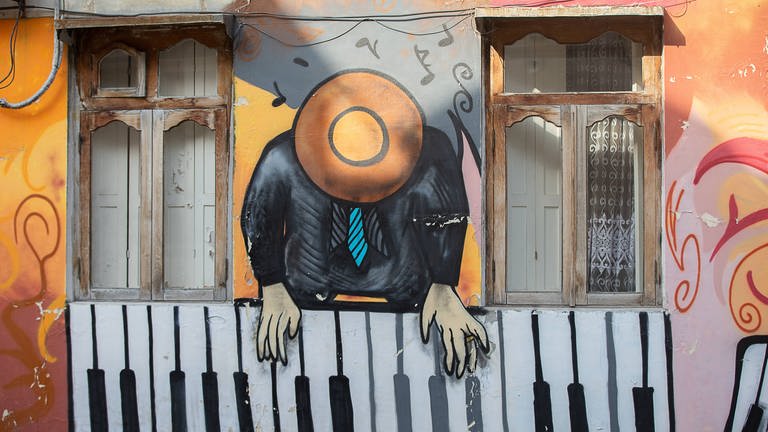 Grafitti "Piano-Spieler" an einer Hauswand in Batumi, Georgien.