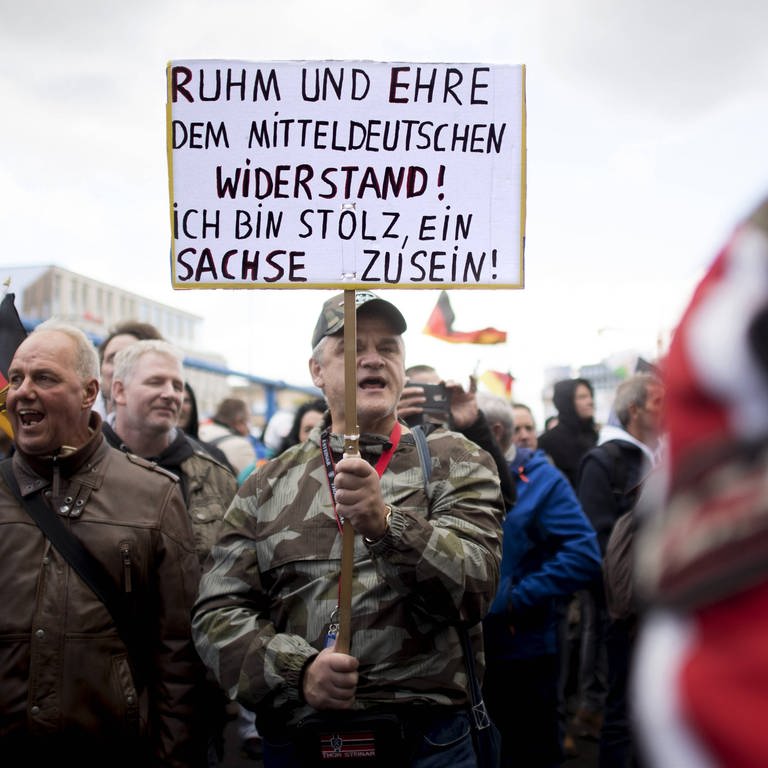 Demonstranten mit Plakat "Ruhm und Ehre dem Mitteldeutschen Widerstand. Ich bin Stolz ein Sachse zu sein" am Tag der Deutschen Einheit am 3. Oktober 2018 in Berlin (Foto: IMAGO, imago images / IPON)