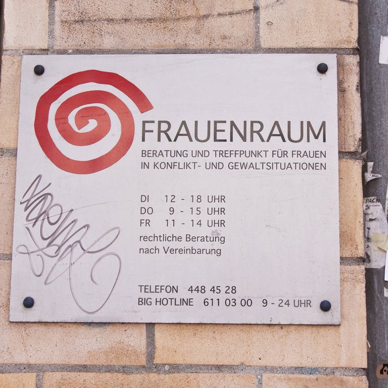 Schild an einer Hauswand mit der Aufschrift "Frauenraum": Beratung und Treffpunkt für Frauen in Konflikt- und Gewaltsituationen in Berlin