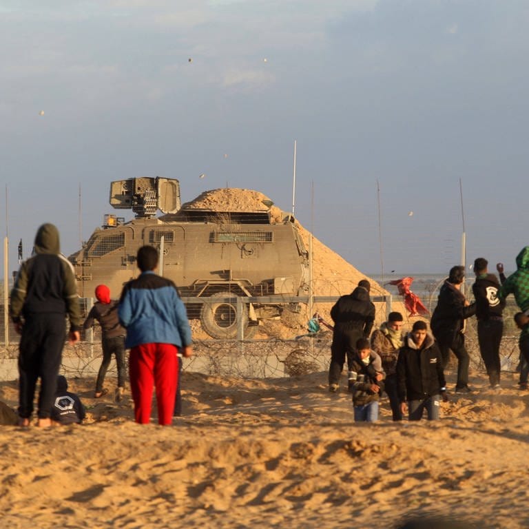 Palästinensische Demonstranten stehen israelischen Truppen gegenüber an einem Stacheldrahtzaun entlang der Grenze zu Israel östlich von Rafah im südlichen Gazastreifen (27. Dezember 2019) (Foto: IMAGO, imago images/UPI Photo)