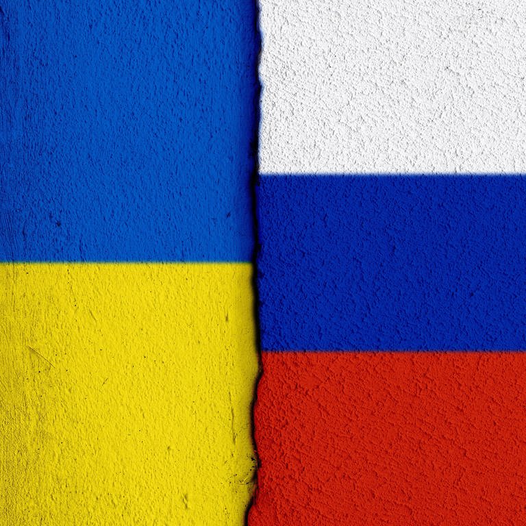 Nationalflaggen der Ukraine sowie von Russland im Anschnitt sowie einem Riss zwischen beiden Parteien. (Foto: picture-alliance / Reportdienste,  / SULUPRESS.DE | Torsten Sukrow)