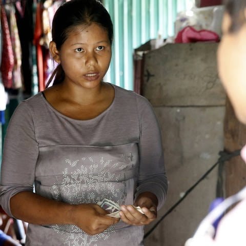 Kreditsachbearbeiter für Mikrofinanzierung in Kambodscha besucht eine Kundin zu Hause. Mikrokredite galten lange als Wunderwaffe im Kampf gegen Armut. Doch am Beispiel von Kambodscha zeigt sich die Kehrseite von Mikrokrediten: Die Zinsen dort sind enorm hoch, viele Kreditnehmer deshalb überschuldet, eine gesetzliche Pfändungsgrenze gibt es nicht. (Foto: IMAGO, IMAGO / UIG)