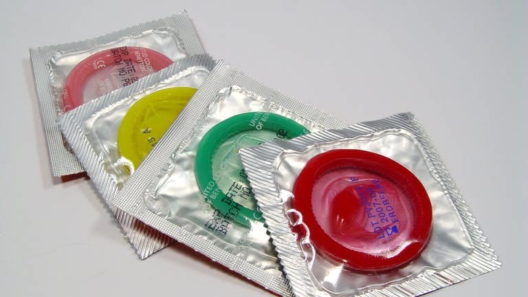 Vier Kondome in verschiedenen Farben auf einem Tisch