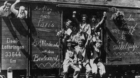 Soldaten in einem offenen Eisenbahnwaggon, winken in die Kamera, Aufschriften auf dem Waggon. (Foto: SZ Photo - Scherl) Soldaten in einem offenen Eisenbahnwaggon, winken in die Kamera, Aufschriften auf dem Waggon.