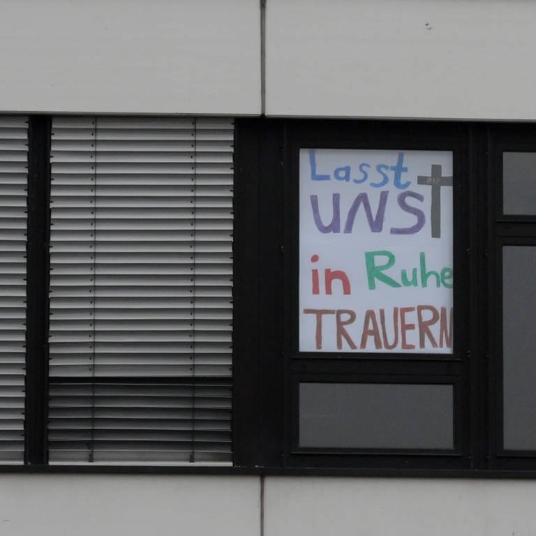 "Lasst uns in Ruhe trauern!" steht auf einem Plakat in einem Fenster der Albertville-Realschule in Winnenden. Stiller Protest gegenüber der Presse nach dem Amoklauf am 11. März 2009. (Foto: IMAGO, IMAGO / Hartenfelser)