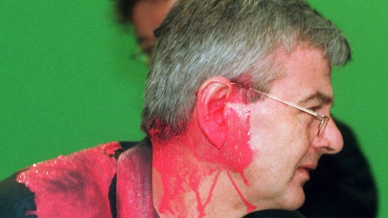 Joschka Fischer (Grüne), kurz nachdem er auf dem Sondersparteitag der Grünen zum Kosovo-Krieg von einem Farbbeutel getroffen wurde. (Foto: dpa Bildfunk, picture alliance/dpa | Bernd Thissen)