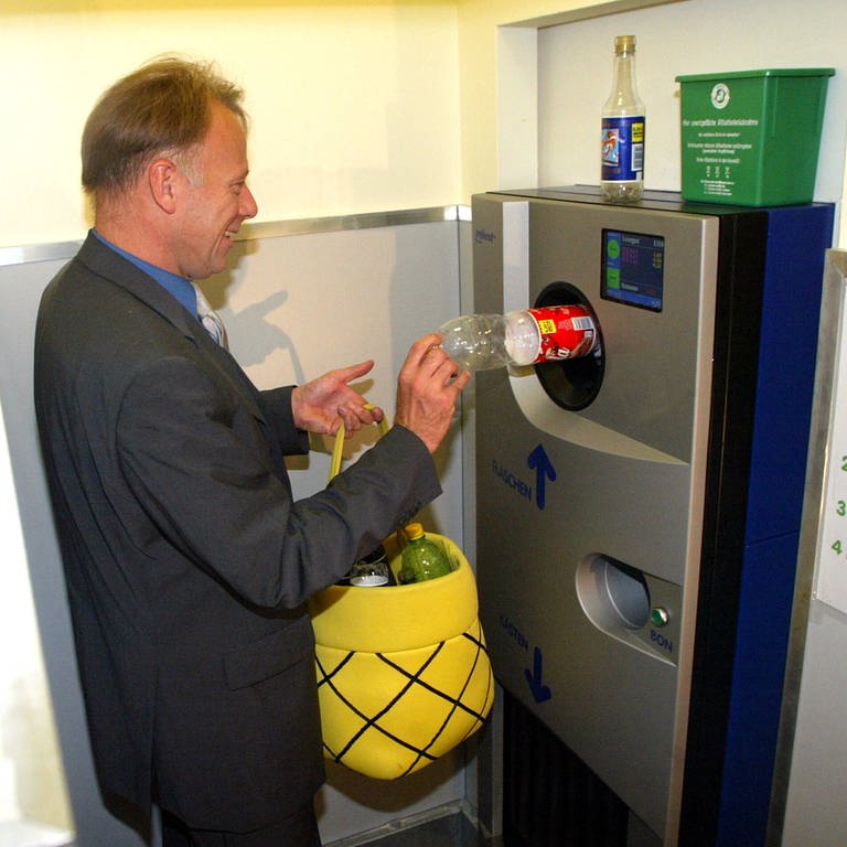 Bundesumweltminister Juergen Trittin steckt 2003 eine Flasche in einen Getränkeautomaten (Foto: IMAGO, IMAGO / Uta Wagner)