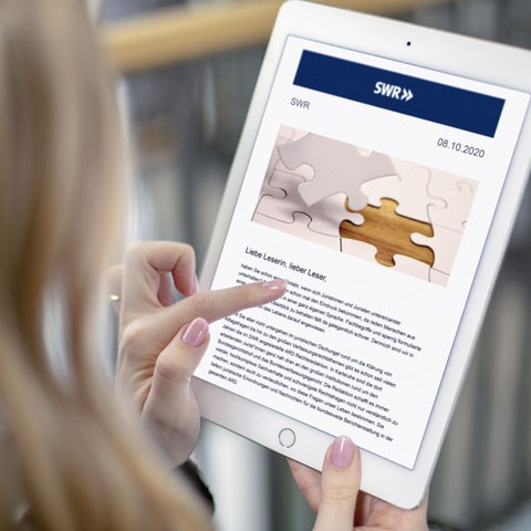 Weibliche Abonnentin liest eine Ausgabe des SWRlive!-Newsletters mit Informationen zu den Live-Events (Foto: SWR)