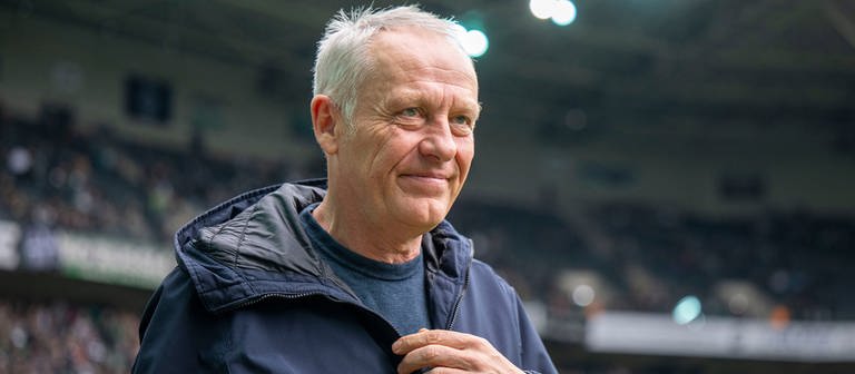 SC Freiburgs Trainer Christian Streich betritt lächelnd das Stadion. (Foto: SWR, picture alliance/Reportdienst)