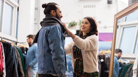 Paar probiert im Second Hand Laden Kleidung an (Foto: Adobe Stock) Paar probiert im Second Hand Laden Kleidung an