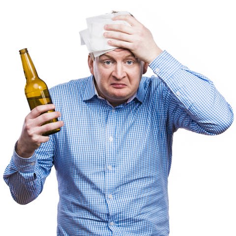 Mann mit Bierflasche in der Hand hat Kopfschmerzen: Ob Bier oder Wein ist egal: Wer einen Kater vermeiden will, muss auf die Menge des Alkohols achten