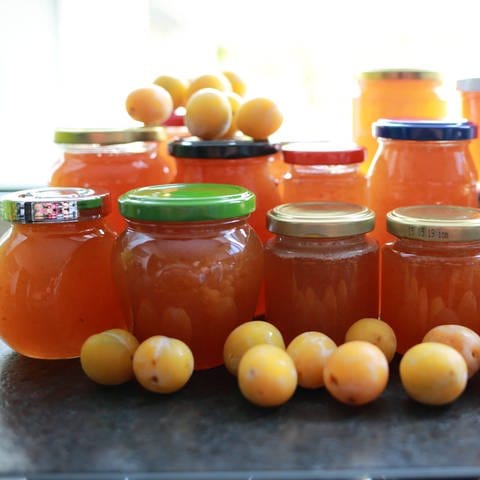 Verschiedene Gläser und Früchte: selbst gemachte Marmelade ist lecker