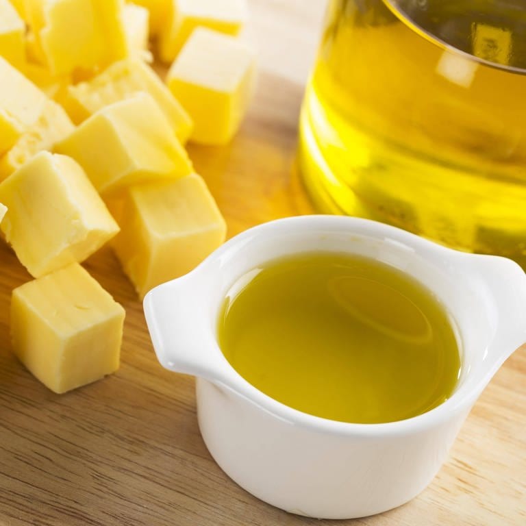 Butterwürfel und eine Flasche mit Olivenöl: Ob Stoffe fest, flüssig oder gasförmig sind, hängt davon ab, wie stark die einzelnen Moleküle sich gegenseitig anziehen – welche Kräfte also zwischen ihnen wirken. 