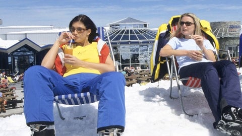 Zwei Frauen und ein Mann relaxen beim Sonnenbad vor einer Bergstation: Menschen mit mittelheller Haut üssten im Februar mindestens eine Dreiviertelstunde in die pralle Mittagssonne gehen, um zumindest einen Teil ihres Tagesbedarfs an Vitamin D zu decken. Das gilt aber nur auf 500 Metern Höhe und wenn Gesicht, Arme und Hände unbedeckt sind – kein Programm für Frostbeulen. (Foto: IMAGO, IMAGO / blickwinkel)