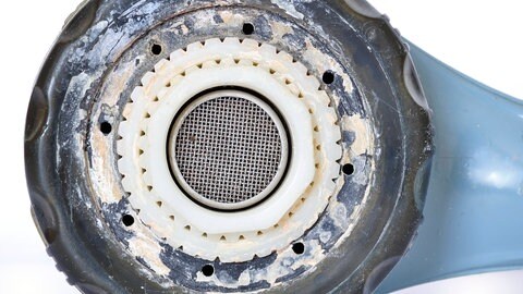 Verkalkter Duschkopf: Kalk in Perlator und Duschkopf ist ein idealer Nährboden für Mikroorganismen. Man sollte diese daher regelmäßig mit Säure reinigen. (Foto: IMAGO, IMAGO / Zoonar)
