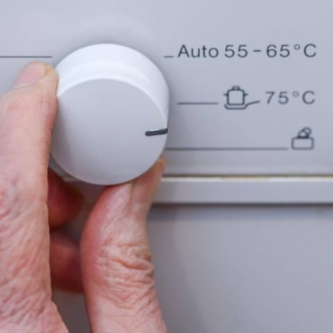Temperaturregler an einer Geschirrspülmaschine: Die Spülmaschine zu benutzen ist das Beste, was Sie machen können, um zu Hauser des Geschirr sauber zu bekommen. Wenn Sie hygienisch auf Nummer sicher gehen wollen, nehmen Sie das Normalprogramm oder sogar das Proramm mit dem Symbol "Topf und zwei Untertassen", also das 75-Grad-Programm. 