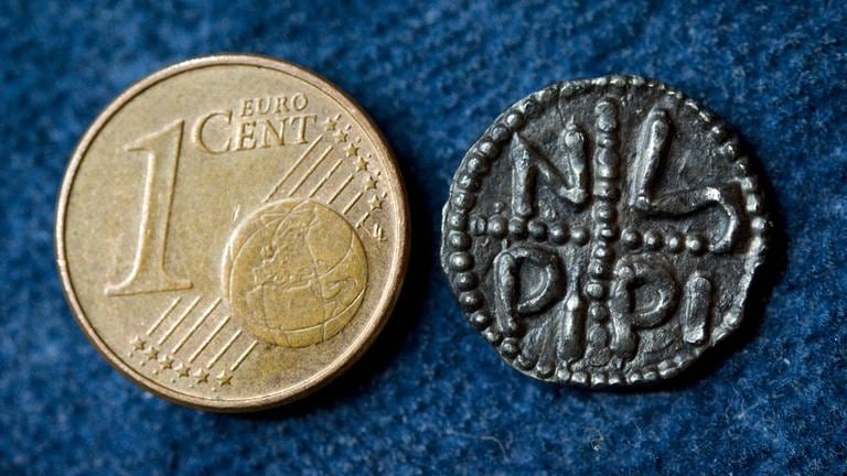Der wohl älteste deutsche Pfennig, der Denar von Pippin III. (714-768), neben einer modernen Cent-Münze