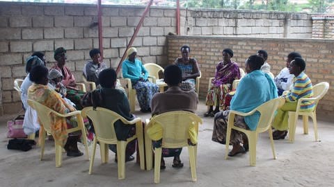 Mehrere Personen sitzen in einem Kreis: Überlebende sexualisierter Gewalt, darunter auch Mütter von "Children Born of War" im Rahmen der Arbeit von Survivors Fund